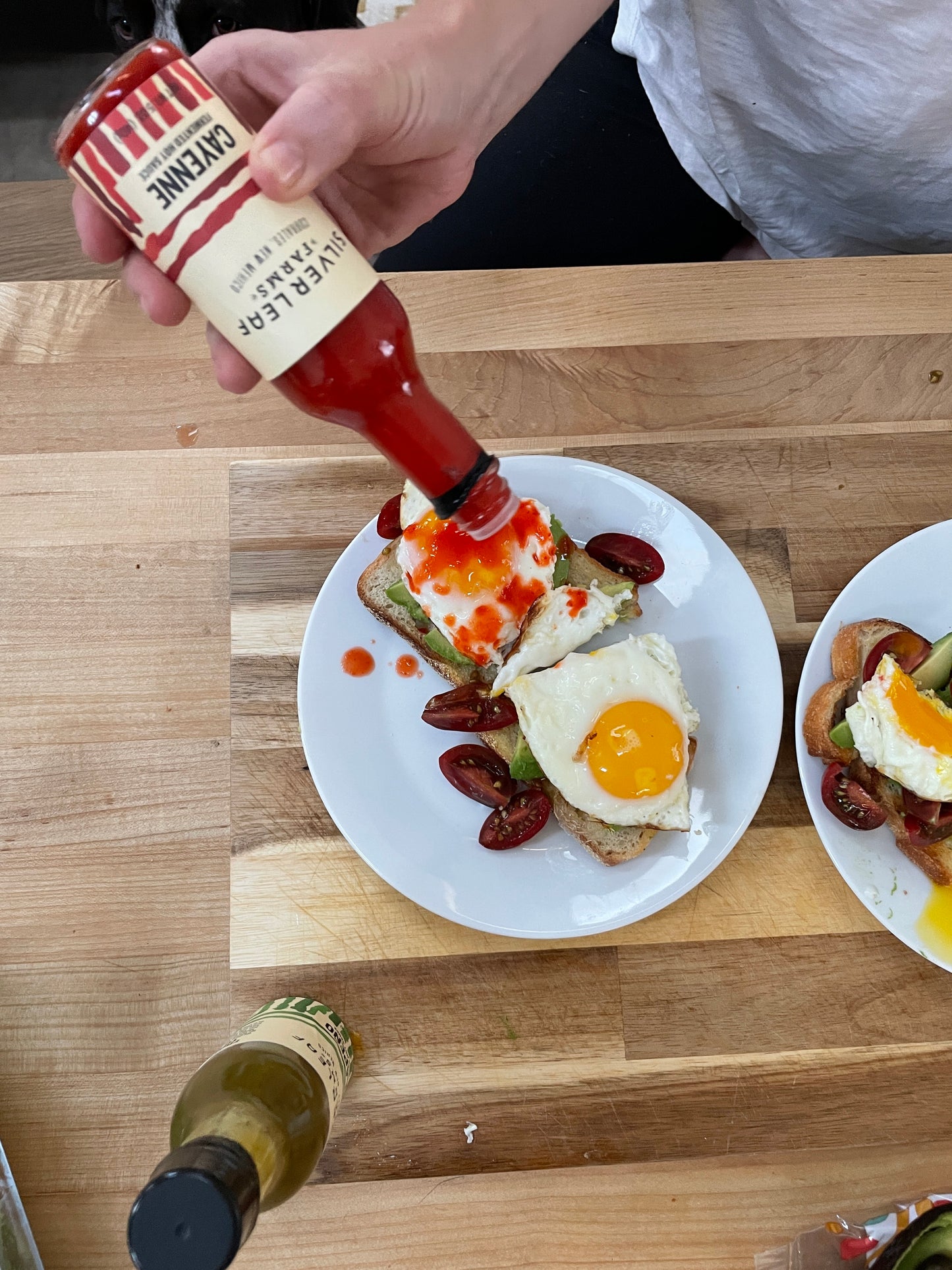 Cayenne Fermented Hot Sauce from Silver Leaf Farms being poured on fried eggs on avocado toast