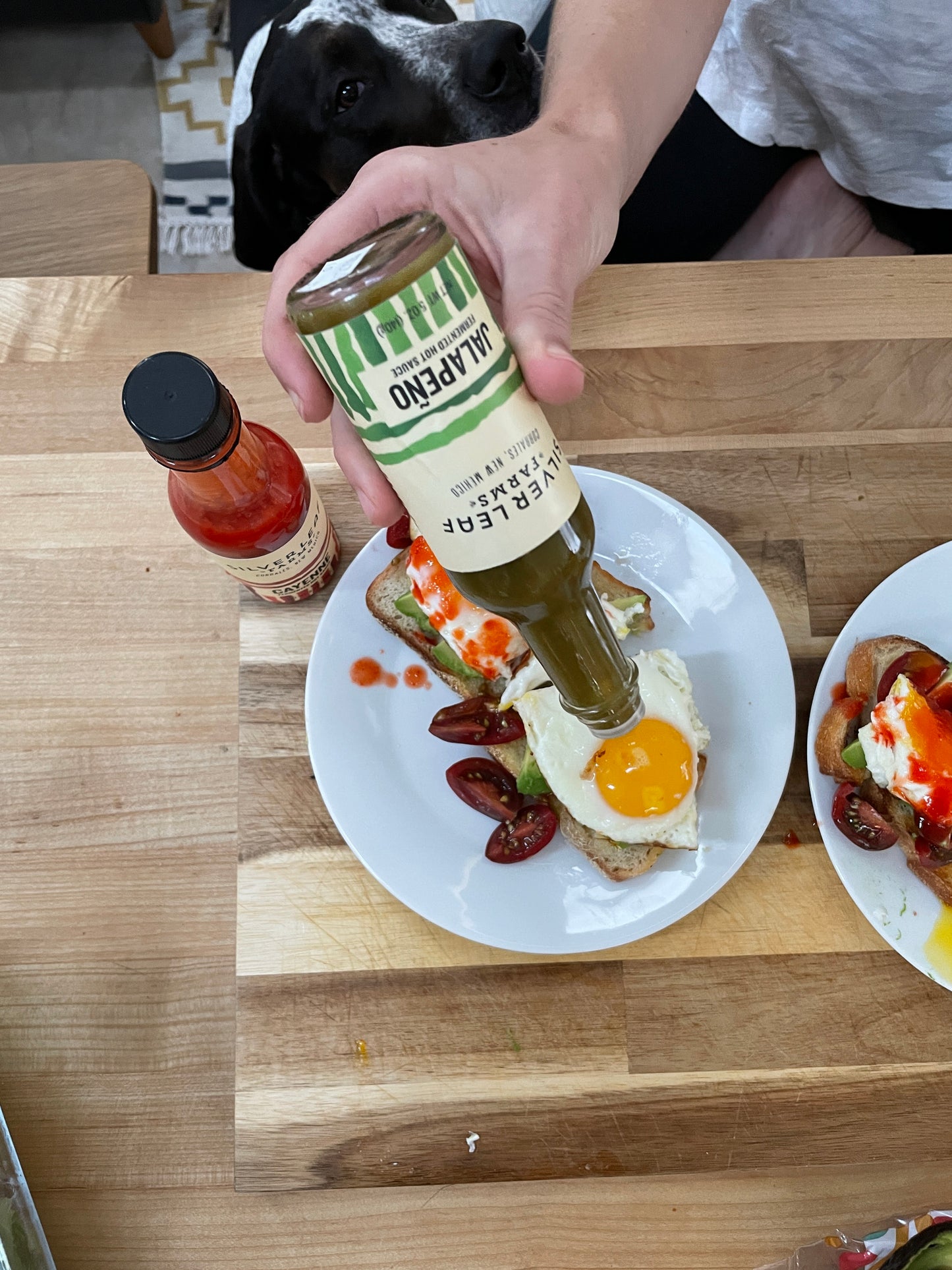 Silver Leaf Farms Jalapeño Fermented Hot Sauce being poured on a fried egg on avocado toast